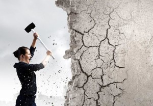 Young attractive businesswoman with hammer in hands